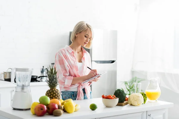 Atractiva Mujer Rubia Escribiendo Cuaderno Cerca Ingredientes — Foto de Stock