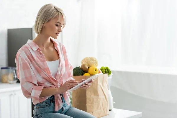 Attractive Blonde Woman Using Digital Tablet Paper Bag Ingredients — Stock Photo, Image