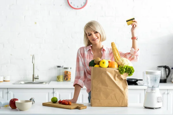 Happy Blonde Girl Holding Credit Card Paper Bag Groceries — Stock Photo, Image