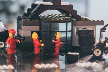 Kiev, Ukrayna - 15 Mart 2019: kırmızı taşıyan lastik lego minifigures ise diğer heykelcik ler servis istasyonunda ağızlıkta bağırıyor