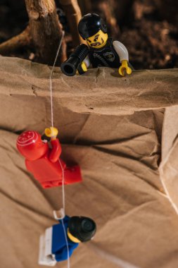 Kiev, Ukrayna - 15 Mart 2019: oyuncak polis ağızlıkta bağırırken plastik lego heykelcikler halat tırmanma