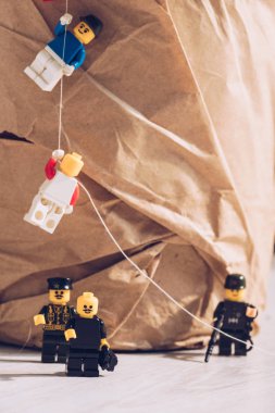 KYIV, UKRAINE - MARCH 15, 2019: lego policemen standing with weapon while plastic lego figurines climbing rope  clipart
