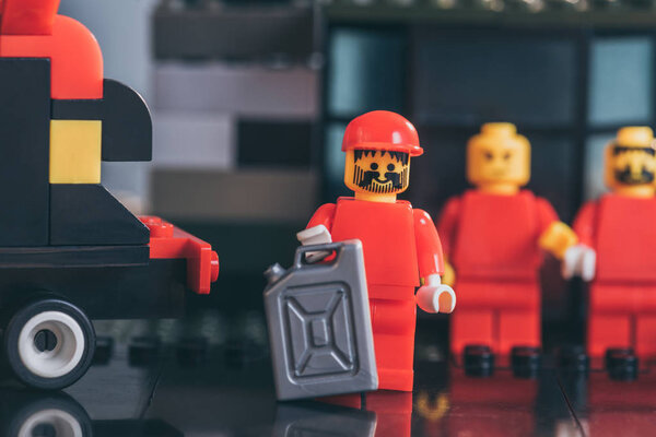 КИЕВ, УКРАИНА - 15 марта 2019 года: Выборочный фокус фигурки лего в красном с игрушечной канистрой бензина
