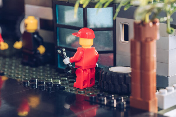 KYIV, UKRAINE - MARCH 15, 2019: Selective Focus of lego mechanic figurine in red with wrench