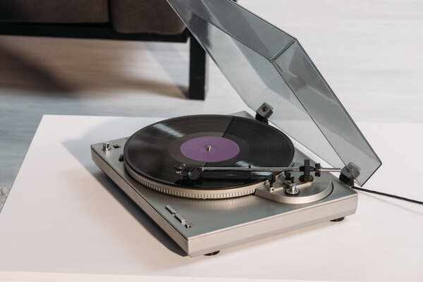 vintage vinyl record player on white table at home