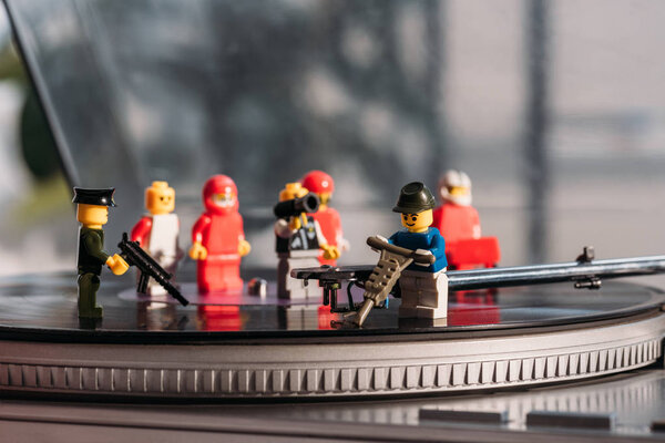 KYIV, UKRAINE - MARCH 15, 2019: selective focus of plastic lego figurines fixing vinyl record player