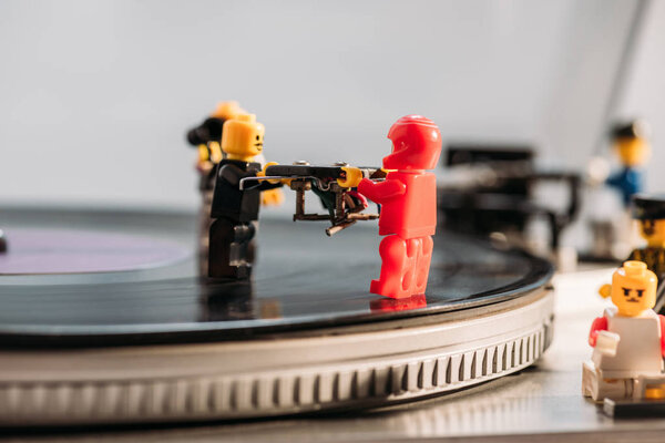 KYIV, UKRAINE - MARCH 15, 2019: selective focus of plastic lego figurines fixing vinyl record player
