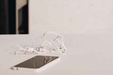 kopyalama alanı ile beyaz masada boş ekranlı kulaklıklar ve akıllı telefon