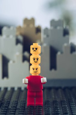Kiev, Ukrayna - 15 Mart 2019: lego bloklarından yapılmış binaların önünde başları üzerinde kayıtsız, gülen ve öfkeli yüzleri ile kırmızı lego heykelcik