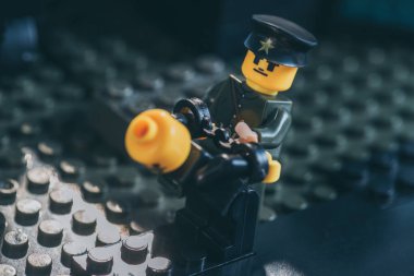 Kiev, Ukrayna - 15 Mart 2019: üniformalı polis heykelciği ve siyah lego figürünü tutuklayan şapka