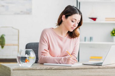 evde masada otururken çekici konsantre kadın Notebook yazma