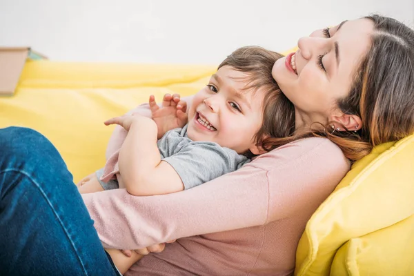 Feliz Madre Con Hijo Alegre Descansando Sofá Amarillo Casa — Foto de Stock