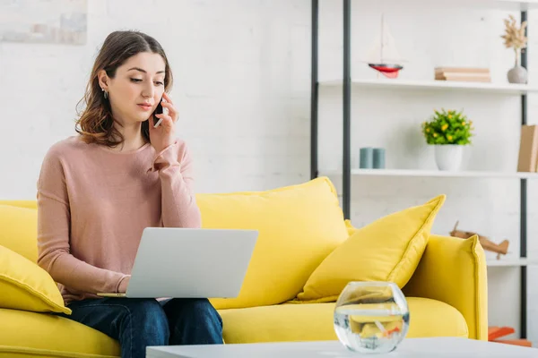 Serious Woman Talking Smartphone Using Laptop While Sitting Sofa Table — Stock Photo, Image