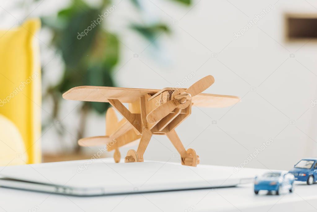 selective focus of wooden plane model and miniature car models 