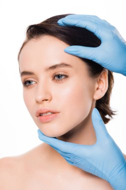 beyaz üzerinde izole güzel kadının yüzüne dokunmadan mavi lateks eldiven plastik cerrah kırpılmış görünümü
