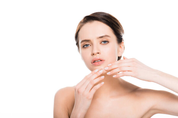 привлекательная обнажённая женщина касается подбородка с прыщом и смотрит на камеру, изолированную на белом
 