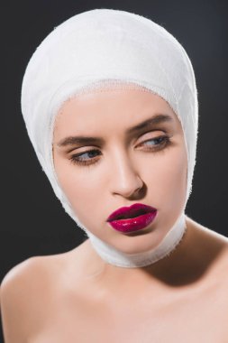 Kırmızı dudaklar ve bandajlı kafası ile güzel genç kadın gri izole 