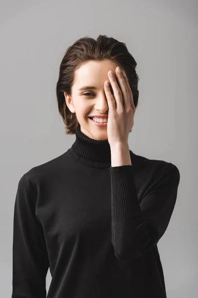 Happy Young Woman Black Jumper Covering Eye Isolated Grey — Stock Photo, Image