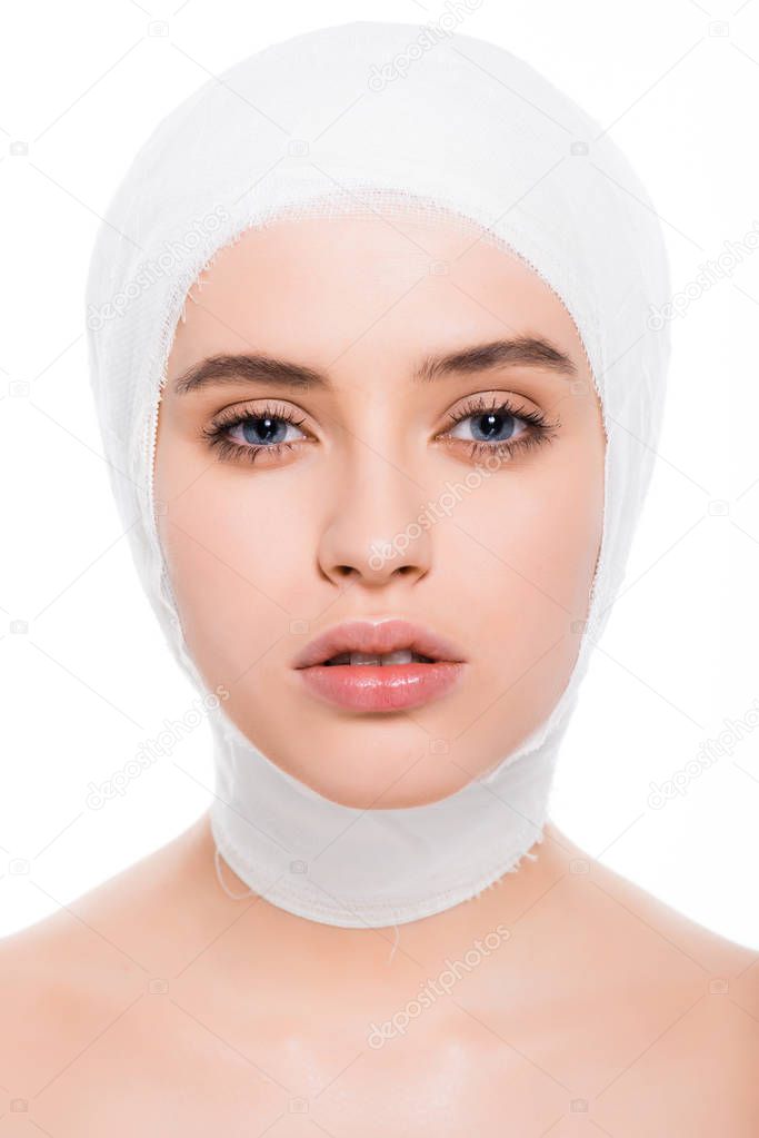 attractive young woman with bandaged head looking at camera isolated on white 