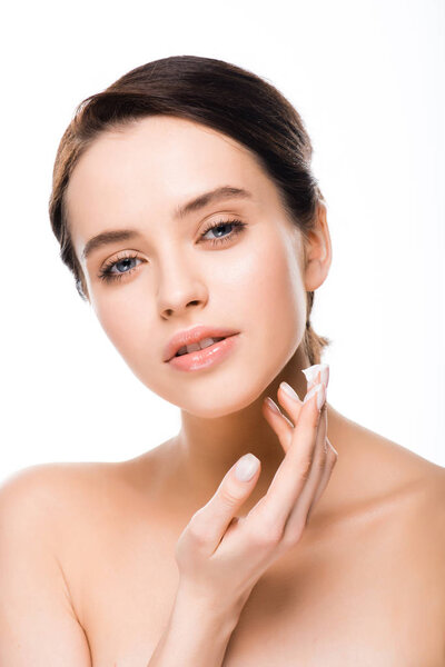 attractive woman applying face cream and looking at camera isolated on white 