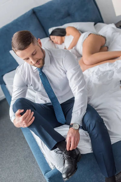 选择性焦点胡须男子在西装触摸鞋带附近的熟睡妇女 — 图库照片