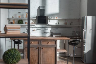 ahşap masa sandalye ve buzdolabı ile modern mutfakta güneş ışığı 