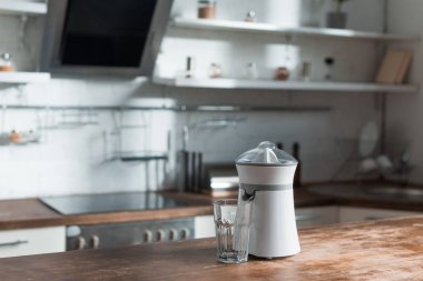 sunlight in kitchen with juicer and glass on wooden surface  clipart