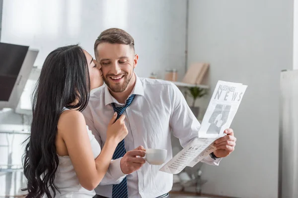 Brunette Girl Kissing Cheek Handsome Man Suit Holding Newspaper — Stock Photo, Image