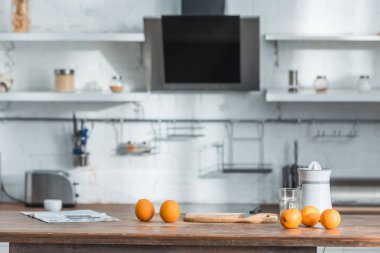 ahşap masa üzerinde juicer, cam ve lezzetli organik portakal ile modern mutfak 