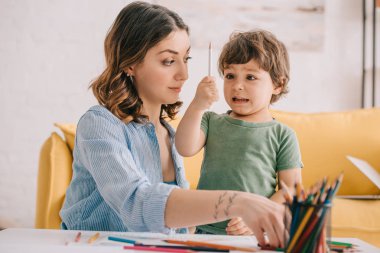 anne ile çizim yaparken renk kalem tutan hayran çocuk