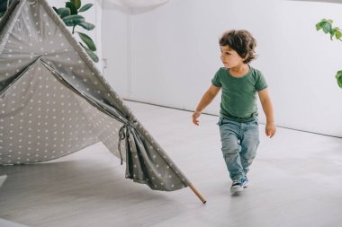 Gri wigwam yakın kot yürümeye başlayan çocuğun tam uzunlukta görünümü