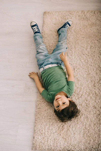 Overhead View Curious Little Boy Green Shirt Lying Carpet — Stock Photo, Image