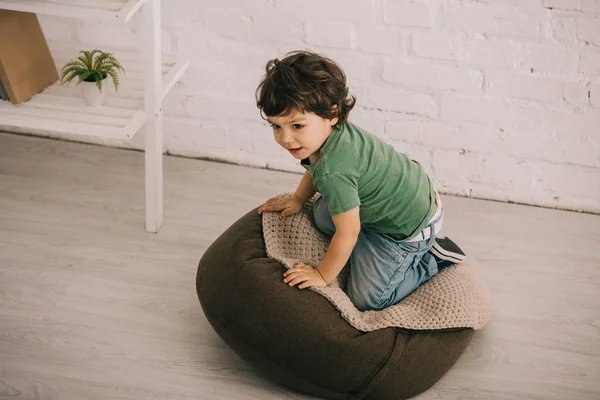 Liten Pojke Grön Shirt Sitter Sittpuff Vardagsrummet — Stockfoto