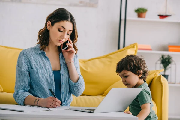 Kid Tittar Laptop Medan Mamma Pratar Smartphone — Stockfoto