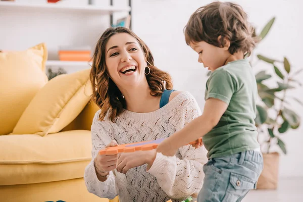 Lachende Mutter Spielt Mit Kleinem Sohn Wohnzimmer — Stockfoto
