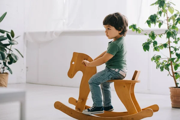 Παιδί Που Κάθεται Ξύλινο Κουνιστό Άλογο Στο Σαλόνι — Φωτογραφία Αρχείου