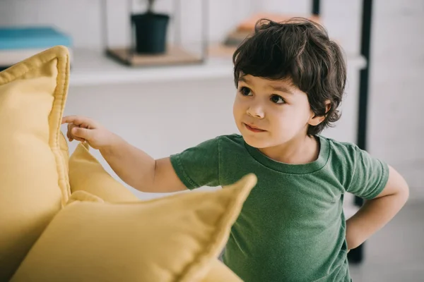 Neugieriges Kind Steht Neben Gelben Kissen Wohnzimmer — Stockfoto
