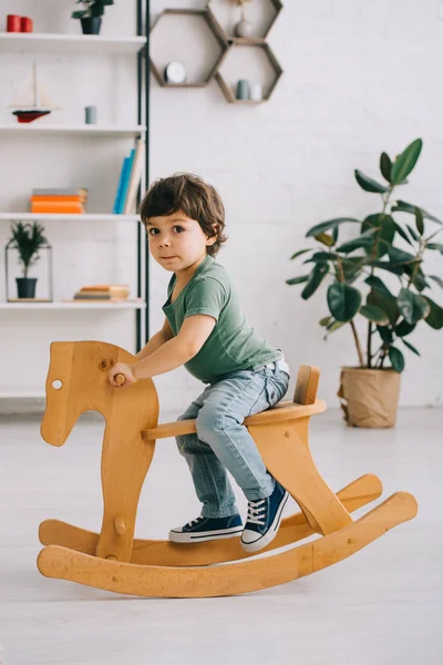 Dziecko Siedzi Drewnianym Konia Biegunach Salonie — Zdjęcie stockowe