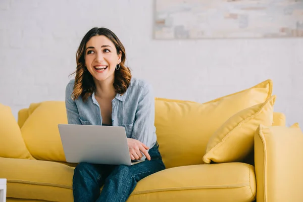 Sorrindo Muito Freelancer Sentado Sofá Amarelo Com Laptop — Fotografia de Stock