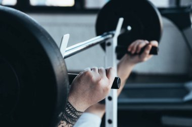 spor salonunda barbell ile dövmeli adam eğitim kırpılmış görünümü