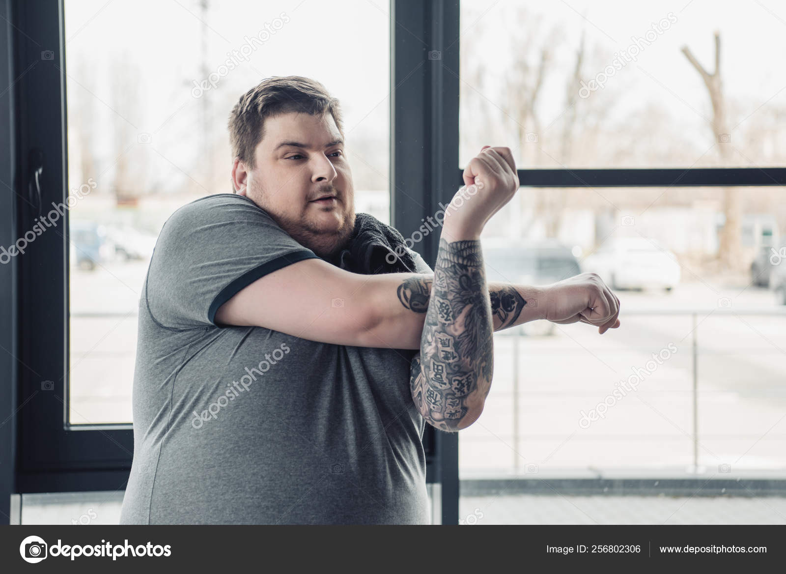 Overweight Tattooed Man Grey Shirt Stretching Arms Gym — Stock