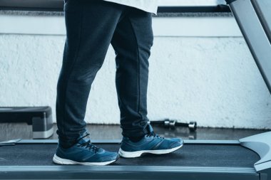 spor merkezinde koşu bandı üzerinde çalışan eğitmenler kilolu adam kırpılmış görünümü