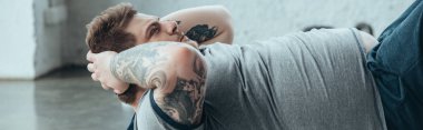 kilolu dövmeli adam panoramik çekim spor merkezinde egzersiz kadar oturup yapıyor