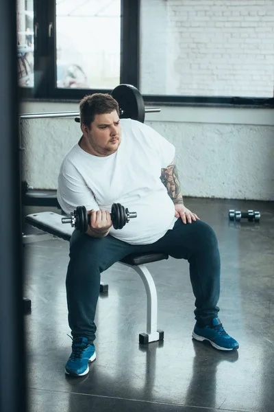 Sobrepeso Tatuado Homem Sentado Exercitando Com Halteres Centro Esportes — Fotografia de Stock