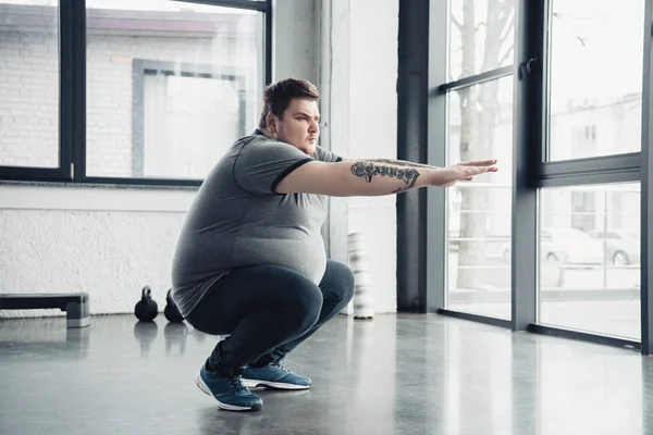 Übergewichtiger Tätowierter Mann Macht Kniebeugen Sportzentrum — Stockfoto