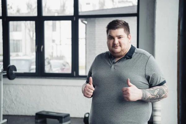 Overweight Tattooed Man Looking Camera Showing Thumbs Gym Copy Space — Stock Photo, Image