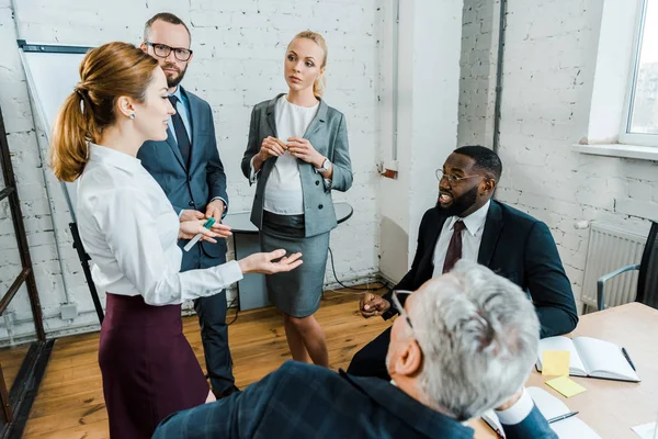 Blonde Pregnant Businesswoman Looking Woman Gesturing While Talking Multicultural Coworkers — Stock Photo, Image