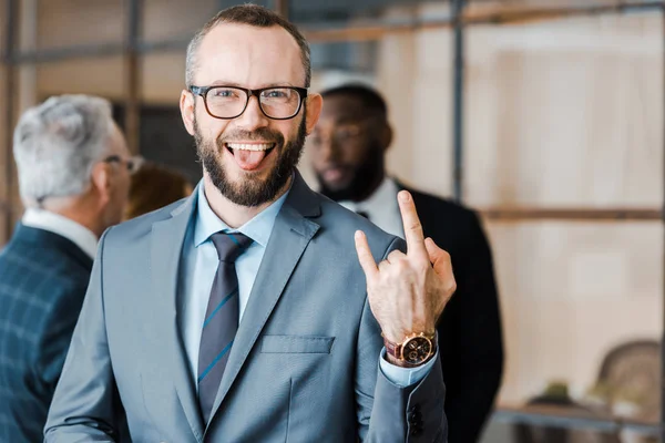 Enfoque Selectivo Empresario Feliz Mostrando Lengua Signo Roca Cerca Compañeros — Foto de Stock