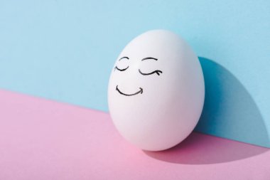 kopya alanı ile mavi ve pembe mutlu yüz ifadesi ile yumurta