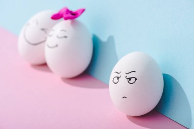 mavi ve pembe üzerinde mutlu yüzleri ile yumurta yakın kızgın yüz ifadesi ile yumurta seçici odak